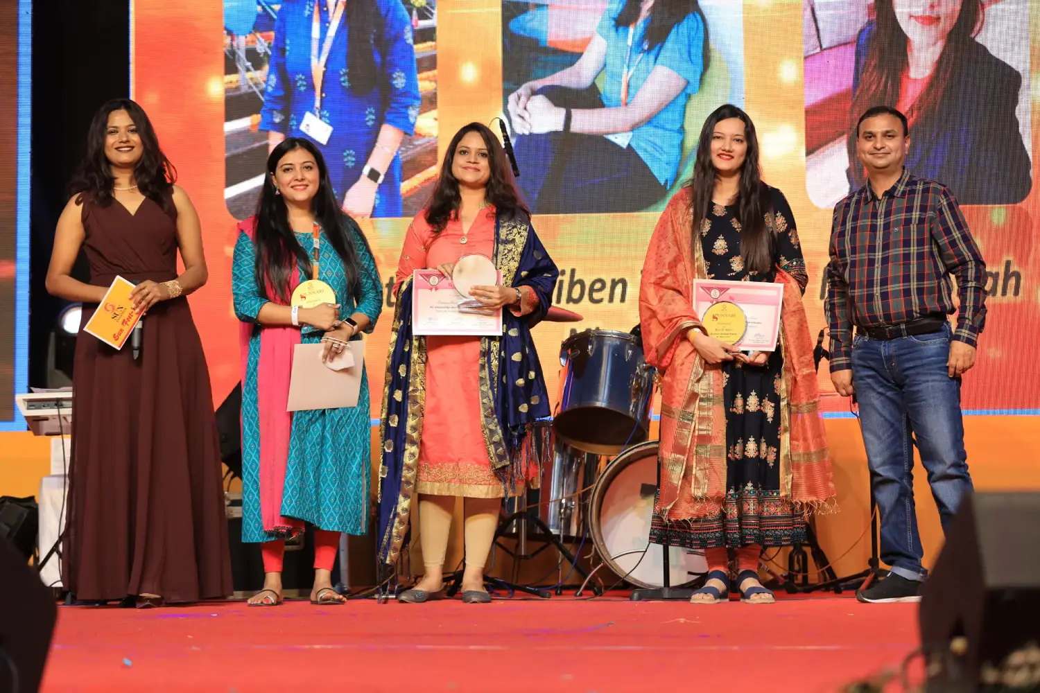 Group of men posing with large cartoon character inflatable figures at night outdoors